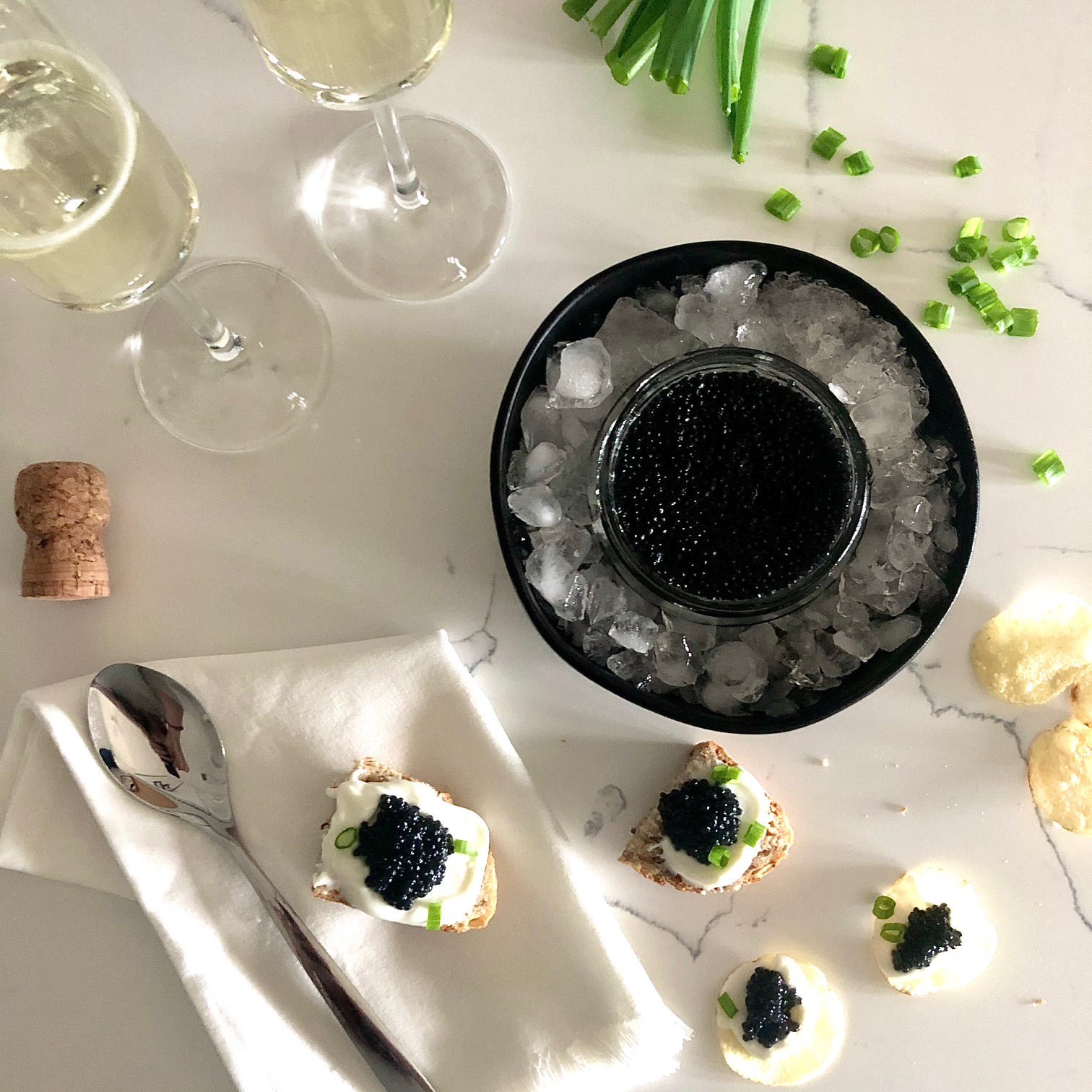 Champagne and vegan caviar on toast points and potato chips with creme fraiche and chives