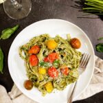 pesto pasta with tomatoes on plate with fork