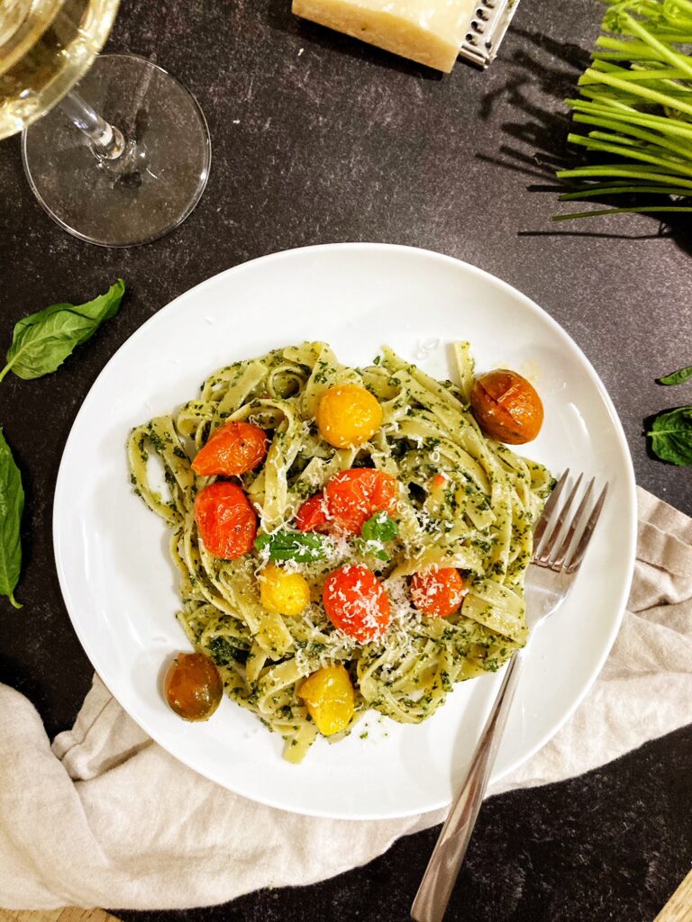 pesto pasta with tomatoes on plate with fork