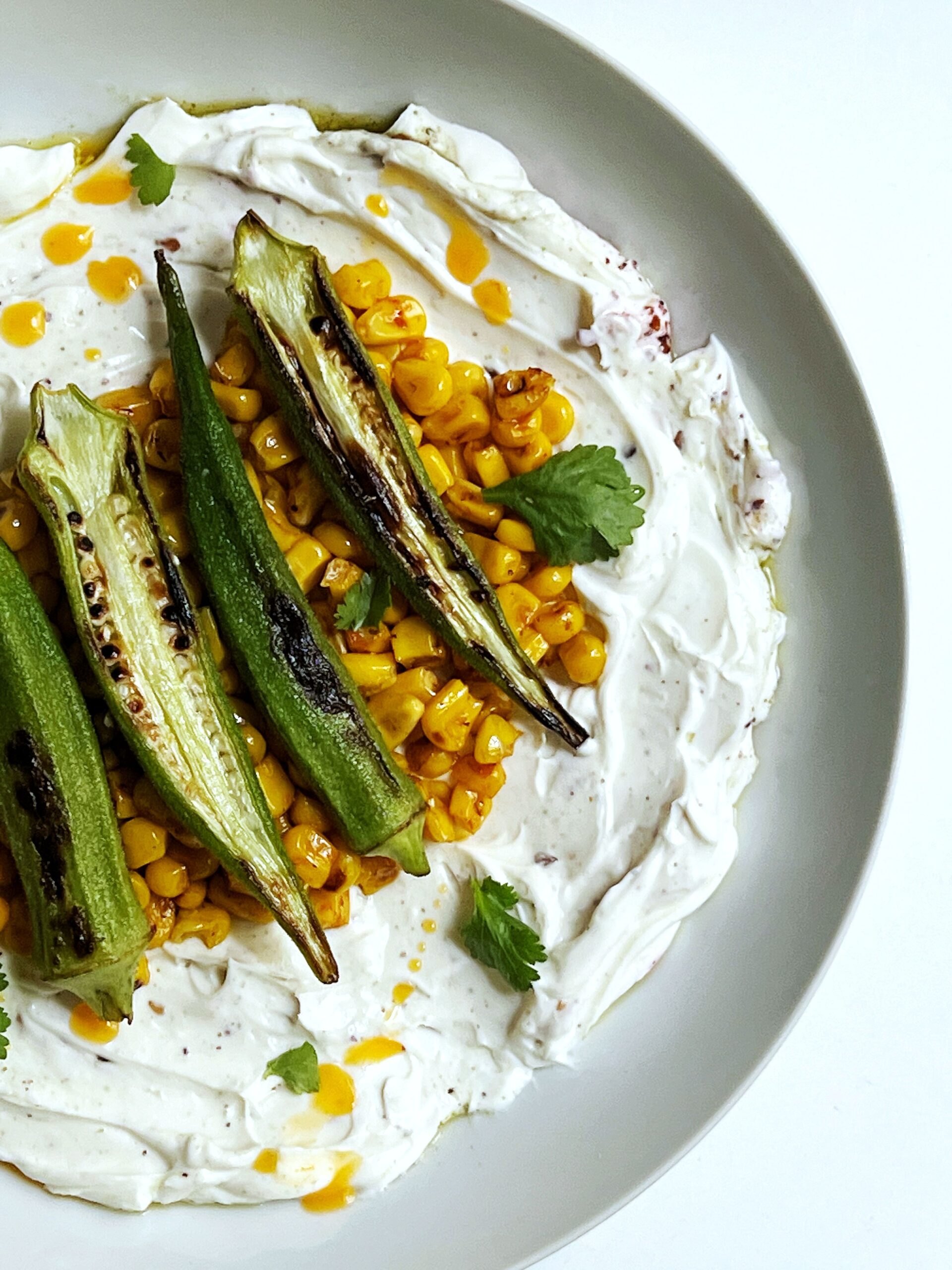 seared okra over charred corn tossed in harissa butter and served over labneh
