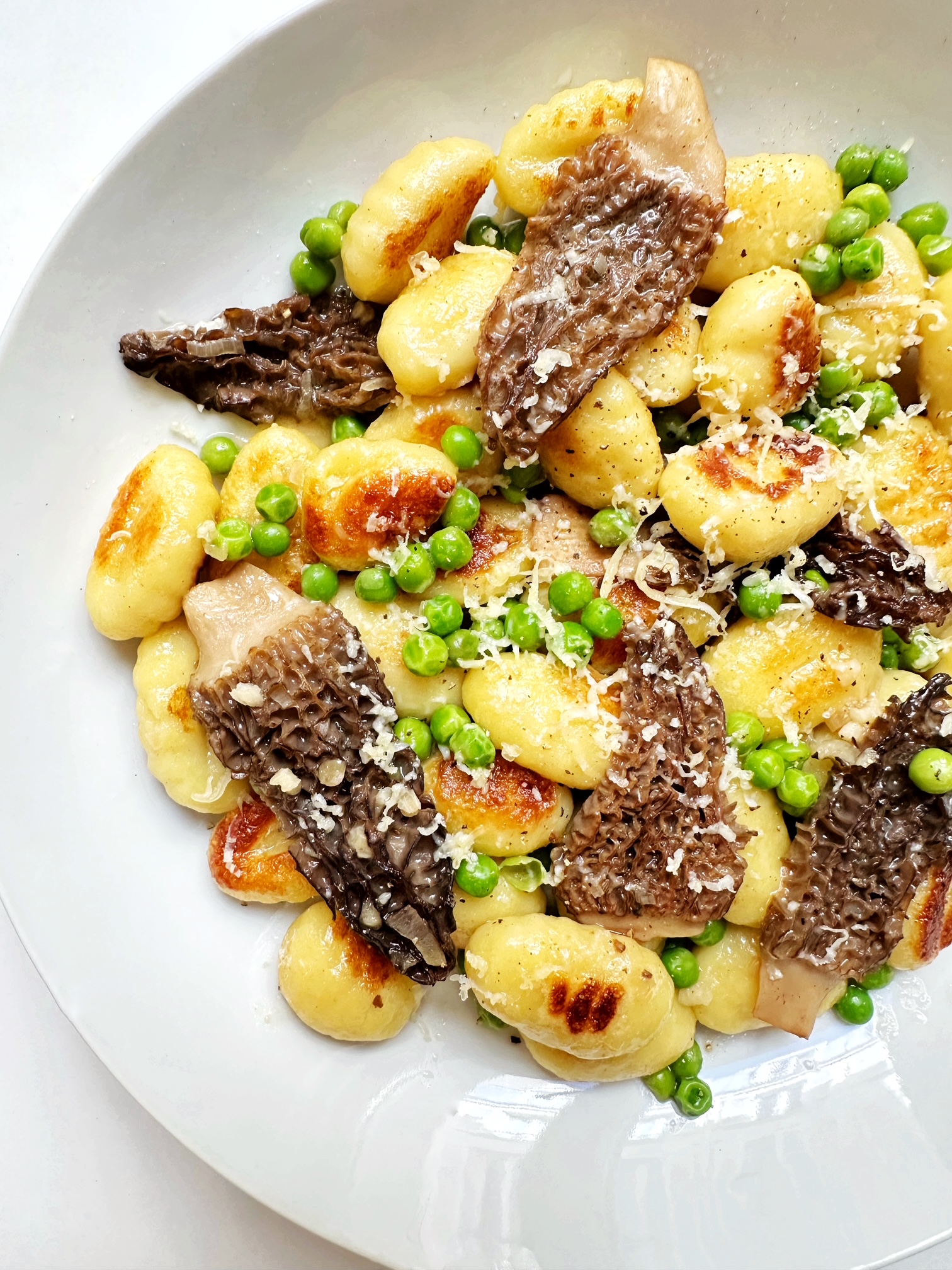 seared gnocchi with morels and english peas in a butter sauce